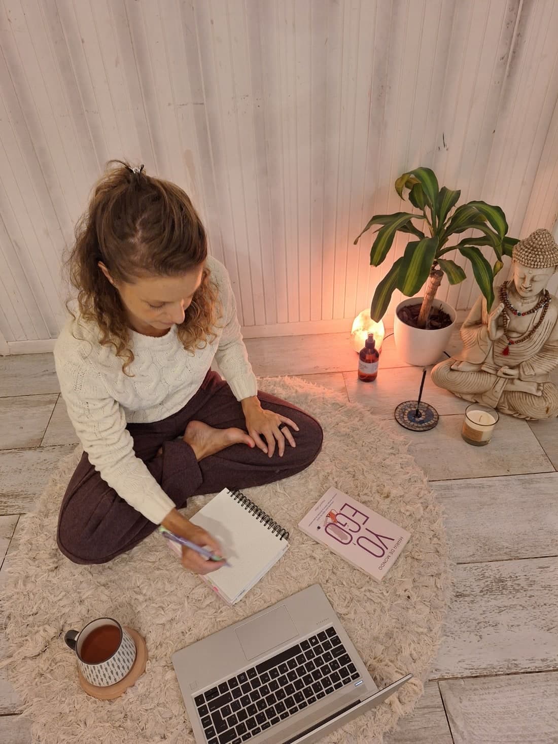 Clau Guillan en su espacio holístico, con notebook y cuaderno